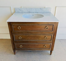 Load image into Gallery viewer, Upgrade your space with this stunning Bramble Cholet single bathroom vanity, where classic design meets modern functionality. Crafted from solid mahogany in a variety of finishes, this piece brings warmth and timeless beauty to any bathroom.
Topped with luxurious marble, with a white American Standard undermount sink. Good Bones Furniture