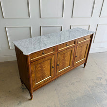 Load image into Gallery viewer, A study in balance and material, the Riley Sideboard draws from European neoclassical design—most notably Louis XVI—reimagined through a quieter, more modern lens. The form is clean and architectural, defined by symmetry, framed panels, and gently tapered legs that give the piece a sense of structure without excess. Cerejeira veneers are carefully bookmatched across each door, revealing a striking cathedral grain that brings movement and depth to the façade. Good Bones Furniture