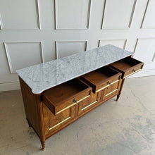 Load image into Gallery viewer, A study in balance and material, the Riley Sideboard draws from European neoclassical design—most notably Louis XVI—reimagined through a quieter, more modern lens. The form is clean and architectural, defined by symmetry, framed panels, and gently tapered legs that give the piece a sense of structure without excess. Cerejeira veneers are carefully bookmatched across each door, revealing a striking cathedral grain that brings movement and depth to the façade. Good Bones Furniture