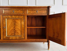 Load image into Gallery viewer, A study in balance and material, the Riley Sideboard draws from European neoclassical design—most notably Louis XVI—reimagined through a quieter, more modern lens. The form is clean and architectural, defined by symmetry, framed panels, and gently tapered legs that give the piece a sense of structure without excess. Cerejeira veneers are carefully bookmatched across each door, revealing a striking cathedral grain that brings movement and depth to the façade. Good Bones Furniture