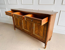 Load image into Gallery viewer, A study in balance and material, the Riley Sideboard draws from European neoclassical design—most notably Louis XVI—reimagined through a quieter, more modern lens. The form is clean and architectural, defined by symmetry, framed panels, and gently tapered legs that give the piece a sense of structure without excess. Cerejeira veneers are carefully bookmatched across each door, revealing a striking cathedral grain that brings movement and depth to the façade. Good Bones Furniture