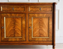 Load image into Gallery viewer, A study in balance and material, the Riley Sideboard draws from European neoclassical design—most notably Louis XVI—reimagined through a quieter, more modern lens. The form is clean and architectural, defined by symmetry, framed panels, and gently tapered legs that give the piece a sense of structure without excess. Cerejeira veneers are carefully bookmatched across each door, revealing a striking cathedral grain that brings movement and depth to the façade. Good Bones Furniture