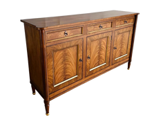 Load image into Gallery viewer, A study in balance and material, the Riley Sideboard draws from European neoclassical design—most notably Louis XVI—reimagined through a quieter, more modern lens. The form is clean and architectural, defined by symmetry, framed panels, and gently tapered legs that give the piece a sense of structure without excess. Cerejeira veneers are carefully bookmatched across each door, revealing a striking cathedral grain that brings movement and depth to the façade. Good Bones Furniture