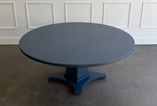 Load image into Gallery viewer, Inspired by Mid-Century design, the Maxwell Round Dining Table pairs clean architectural lines with softened curves for a look that feels modern yet timeless. Crafted from hand-selected oak solids and veneers, its generous 72-inch round top is supported by a substantial pedestal base with four gracefully curved feet. The table has been professionally lacquered by Good Bones Furniture in Farrow & Ball Hague Blue.