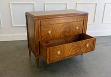 Load image into Gallery viewer, The Lipton 3 Drawer Chest brings classic European character. Crafted from mahogany solids with bookmatched cerejeira veneers, the drawer fronts showcase a dramatic cathedral grain that gives the piece warmth and movement. Fluted corner details, a carved lower border, tapered legs, and decorative brass hardware complete its tailored silhouette. Three spacious drawers on soft close glides. Good Bones Furniture
