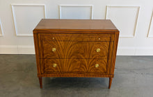 Load image into Gallery viewer, The Lipton 3 Drawer Chest brings classic European character. Crafted from mahogany solids with bookmatched cerejeira veneers, the drawer fronts showcase a dramatic cathedral grain that gives the piece warmth and movement. Fluted corner details, a carved lower border, tapered legs, and decorative brass hardware complete its tailored silhouette. Three spacious drawers on soft close glides. Good Bones Furniture
