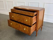 Load image into Gallery viewer, The Lipton 3 Drawer Chest brings classic European character. Crafted from mahogany solids with bookmatched cerejeira veneers, the drawer fronts showcase a dramatic cathedral grain that gives the piece warmth and movement. Fluted corner details, a carved lower border, tapered legs, and decorative brass hardware complete its tailored silhouette. Three spacious drawers on soft close glides. Good Bones Furniture