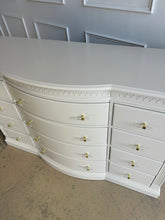 Load image into Gallery viewer, White curved dresser with gold handles in a room setting