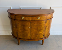 Load image into Gallery viewer, The Lipton Demilune Cabinet is a refined storage piece with a softly curved, architectural silhouette. Crafted from mahogany solids with cerejeira veneers, it showcases a flowing, bookmatched grain pattern across the rounded front for a warm, elevated look. Good Bones Furniture