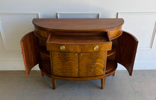 Load image into Gallery viewer, The Lipton Demilune Cabinet is a refined storage piece with a softly curved, architectural silhouette. Crafted from mahogany solids with cerejeira veneers, it showcases a flowing, bookmatched grain pattern across the rounded front for a warm, elevated look. Good Bones Furniture