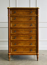 Load image into Gallery viewer, This stately Louis XVI–style chest combines generous storage with a tall, space-conscious silhouette. Crafted from mahogany solids with richly figured cerejeira veneers, it features seven spacious drawers framed by hand-applied gold accents. Fluted corner columns, paneled sides, decorative metal knobs, and tapered legs. Good Bones Furniture