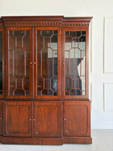 Load image into Gallery viewer, This Georgian-style breakfront china cabinet by Maitland Smith showcases the impeccable construction and richly figured mahogany the maker is known for. The upper cabinet features an illuminated interior behind glass-paneled doors, with adjustable glass shelves that beautifully display china, books, or collected objects. The top is made in three separate sections for easier transport and installation. Good Bones Furniture