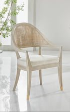 Load image into Gallery viewer, The Modern History Lyon Chair blends refined craftsmanship with classic European-inspired design. Its sculptural frame features graceful curves and a woven cane back that creates a light, elegant silhouette while adding natural texture. A generously upholstered seat provides comfort for extended dining or occasional seating. Brass boot details at the feet add a tailored accent while protecting the legs. Good Bones Furniture