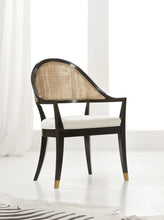 Load image into Gallery viewer, The Modern History Lyon Chair blends refined craftsmanship with classic European-inspired design. Its sculptural frame features graceful curves and a woven cane back that creates a light, elegant silhouette while adding natural texture. A generously upholstered seat provides comfort for extended dining or occasional seating. Brass boot details at the feet add a tailored accent while protecting the legs. Good Bones Furniture