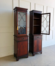 Load image into Gallery viewer, This elegant pair of mahogany display cabinets offers timeless English-inspired styling and exceptional versatility. Rich mahogany veneers showcase beautiful grain patterns throughout, while the astragal-glazed doors add architectural character and provide the perfect backdrop for displaying books, collectibles, china, or decorative objects. Each cabinet features adjustable upper shelving, a convenient storage drawer, and a lower cabinet with additional concealed storage. Good Bones Furniture