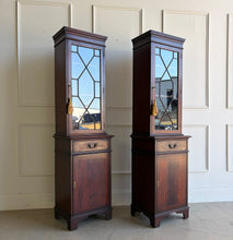 Load image into Gallery viewer, This elegant pair of mahogany display cabinets offers timeless English-inspired styling and exceptional versatility. Rich mahogany veneers showcase beautiful grain patterns throughout, while the astragal-glazed doors add architectural character and provide the perfect backdrop for displaying books, collectibles, china, or decorative objects. Each cabinet features adjustable upper shelving, a convenient storage drawer, and a lower cabinet with additional concealed storage. Good Bones Furniture