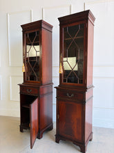 Load image into Gallery viewer, This elegant pair of mahogany display cabinets offers timeless English-inspired styling and exceptional versatility. Rich mahogany veneers showcase beautiful grain patterns throughout, while the astragal-glazed doors add architectural character and provide the perfect backdrop for displaying books, collectibles, china, or decorative objects. Each cabinet features adjustable upper shelving, a convenient storage drawer, and a lower cabinet with additional concealed storage. Good Bones Furniture