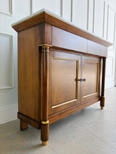 Load image into Gallery viewer, The Philippe Sideboard brings French Empire-inspired elegance and storage to a dining room, entryway, or living space. Crafted with richly figured cerejeira veneer, it features bookmatched door and drawer fronts, fluted columns, and hand-applied gold highlights. A polished white marble top creates a striking contrast with the warm wood tones. Two spacious drawers and a double-door cabinet with an interior shelf provide ample storage for serving pieces, linens, and other essentials. Good Bones Furniture