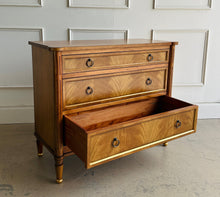 Load image into Gallery viewer, Elegant and effortlessly functional, the Riley Mahogany Chest pairs classic proportions with luxe details. A cerejeira (Brazilian oak) veneer creates a striking feathered grain across the drawer fronts, framed by subtle gold trim that’s echoed on the turned feet. Finished in a warm mahogany tone with mahogany or marble top and fitted with antique brass ring pulls, Riley brings tailored sophistication to bedrooms, entryways, or living spaces while offering generous, everyday storage. Good Bones Furniture