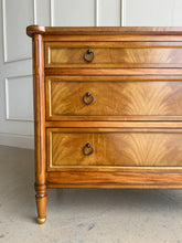 Load image into Gallery viewer, Elegant and effortlessly functional, the Riley Mahogany Chest pairs classic proportions with luxe details. A cerejeira (Brazilian oak) veneer creates a striking feathered grain across the drawer fronts, framed by subtle gold trim that’s echoed on the turned feet. Finished in a warm mahogany tone with mahogany or marble top and fitted with antique brass ring pulls, Riley brings tailored sophistication to bedrooms, entryways, or living spaces while offering generous, everyday storage. Good Bones Furniture