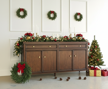 Load image into Gallery viewer, Wooden sideboard with four doors and drawers against a white paneled wall.