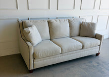 Load image into Gallery viewer, Crafted by renowned North Carolina manufacturer Sherrill Furniture, this custom upholstered sofa offers the exceptional comfort, craftsmanship, and timeless styling that have made the brand a favorite among designers and luxury furniture buyers. Upholstered in a versatile neutral fabric, the sofa features clean transitional track arms, elegant double-row nailhead trim, loose back cushions, and exposed tapered wood feet. Good Bones Furniture