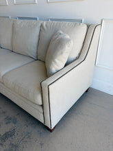 Load image into Gallery viewer, Crafted by renowned North Carolina manufacturer Sherrill Furniture, this custom upholstered sofa offers the exceptional comfort, craftsmanship, and timeless styling that have made the brand a favorite among designers and luxury furniture buyers. Upholstered in a versatile neutral fabric, the sofa features clean transitional track arms, elegant double-row nailhead trim, loose back cushions, and exposed tapered wood feet. Good Bones Furniture