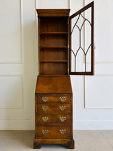 Load image into Gallery viewer, Classic English craftsmanship never goes out of style. This Southampton George III Style Secretary Bookcase is a beautifully proportioned piece that combines elegant display storage, a functional writing desk, and generous drawer storage within a refined, space-saving silhouette. Rich walnut and burl walnut veneers showcase striking natural grain throughout, while the leaded glass door, dentil crown molding, and original Chippendale-style brass hardware add timeless architectural character. Good Bones