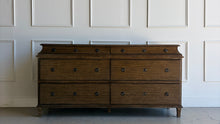 Load image into Gallery viewer, Built from solid mango wood, the Valencia dresser mixes timeless European lines with a relaxed, hand-finished patina. A stepped gallery crowns the case, while framed drawer fronts and reeded, tapered feet give the piece architectural presence. At 72" wide with six generous drawers, it brings warm, natural character and serious storage to the primary bedroom, guest suite, or sophisticated entry.