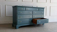 Load image into Gallery viewer, This vintage solid wood 9-drawer dresser has been professionally lacquered in Farrow & Ball Inchyra Blue, a refined blue-green tone that brings depth and understated drama to any room. The clean, traditional lines pair beautifully with new lucite and brass handles, creating a balanced look that feels both classic and freshly updated. Each drawer offers generous storage, making this a functional statement piece for bedrooms, entryways, or living spaces. Good Bones Furniture