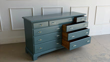 Load image into Gallery viewer, This vintage solid wood 9-drawer dresser has been professionally lacquered in Farrow & Ball Inchyra Blue, a refined blue-green tone that brings depth and understated drama to any room. The clean, traditional lines pair beautifully with new lucite and brass handles, creating a balanced look that feels both classic and freshly updated. Each drawer offers generous storage, making this a functional statement piece for bedrooms, entryways, or living spaces. Good Bones Furniture
