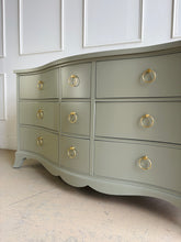 Load image into Gallery viewer, This vintage Table Rock dresser pairs classic construction with a fresh, tailored finish. Lacquered in Sherwin Williams Lauriston Stone, the muted green-gray tone gives the piece a soft, updated presence while still feeling timeless. The gently serpentine front adds movement and elegance, and the new solid brass ring hardware brings a polished contrast to the clean drawer layout. Good Bones Furniture