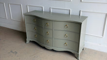 Load image into Gallery viewer, This vintage Table Rock dresser pairs classic construction with a fresh, tailored finish. Lacquered in Sherwin Williams Lauriston Stone, the muted green-gray tone gives the piece a soft, updated presence while still feeling timeless. The gently serpentine front adds movement and elegance, and the new solid brass ring hardware brings a polished contrast to the clean drawer layout. Good Bones Furniture