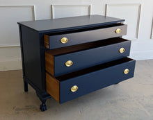Load image into Gallery viewer, Classic craftsmanship meets a bold designer finish in this vintage ball and claw chest, professionally lacquered in Benjamin Moore In the Navy. The rich navy finish highlights the elegant fluted corner details, carved ball and claw feet, and decorative geometric molding across the upper drawer, while new solid brass Hepplewhite drawer pulls add a timeless finishing touch. Good Bones Furniture