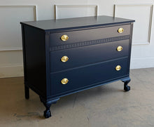 Load image into Gallery viewer, Classic craftsmanship meets a bold designer finish in this vintage ball and claw chest, professionally lacquered in Benjamin Moore In the Navy. The rich navy finish highlights the elegant fluted corner details, carved ball and claw feet, and decorative geometric molding across the upper drawer, while new solid brass Hepplewhite drawer pulls add a timeless finishing touch. Good Bones Furniture