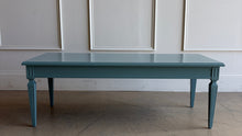 Load image into Gallery viewer, This vintage coffee table pairs classic architectural details with a fresh, colorful finish. Professionally lacquered in Sherwin-Williams Moody Blue, it features a rectangular top, subtly molded apron, carved corner accents, and tapered legs with recessed panel detailing. Good Bones Furniture