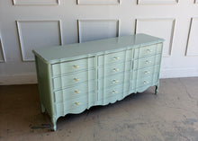 Load image into Gallery viewer, Elegant curves and generous storage give this vintage Dixie dresser a timeless presence, while its fresh custom finish makes it feel entirely current. Lacquered in a Benjamin Moore Saybrook Sage mix, the soft muted green highlights the dresser’s serpentine front, graceful cabriole legs, and classic French-inspired lines. New lucite and brass hardware. Good Bones Furniture