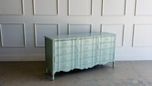 Load image into Gallery viewer, Elegant curves and generous storage give this vintage Dixie dresser a timeless presence, while its fresh custom finish makes it feel entirely current. Lacquered in a Benjamin Moore Saybrook Sage mix, the soft muted green highlights the dresser’s serpentine front, graceful cabriole legs, and classic French-inspired lines. New lucite and brass hardware. Good Bones Furniture