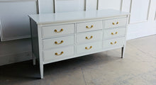 Load image into Gallery viewer, Vintage 9 drawer dresser by Dixie Furniture offers substantial storage within a timeless, beautifully proportioned silhouette. Professionally lacquered in Benjamin Moore Swiss Coffee at 150% strength, its warm creamy-white finish highlights the clean lines, inset drawer fronts, and tapered legs. Good Bones Furniture