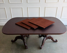 Load image into Gallery viewer, This vintage Drexel Heritage Nine Elms dining set showcases richly figured crotch mahogany veneer framed by contrasting banding. The expansive table rests on two ornately carved pedestal bases and includes three 22-inch leaves, extending it to an impressive 140 inches for large gatherings. Eight coordinating chairs—two armchairs and six side chairs. Good Bones Furniture