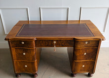 Load image into Gallery viewer, This vintage English-style pedestal desk features richly figured wood veneers, dramatic waterfall drawer fronts, and a gilt-tooled leather writing surface that gives the piece the feel of a collected European library. Influenced by Georgian Revival and campaign-style furniture, the desk blends traditional detailing with softer Art Deco curves, creating a silhouette that feels both timeless and distinctive. Good Bones Furniture