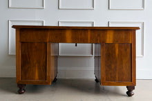 Load image into Gallery viewer, This vintage English-style pedestal desk features richly figured wood veneers, dramatic waterfall drawer fronts, and a gilt-tooled leather writing surface that gives the piece the feel of a collected European library. Influenced by Georgian Revival and campaign-style furniture, the desk blends traditional detailing with softer Art Deco curves, creating a silhouette that feels both timeless and distinctive. Good Bones Furniture