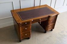 Load image into Gallery viewer, This vintage English-style pedestal desk features richly figured wood veneers, dramatic waterfall drawer fronts, and a gilt-tooled leather writing surface that gives the piece the feel of a collected European library. Influenced by Georgian Revival and campaign-style furniture, the desk blends traditional detailing with softer Art Deco curves, creating a silhouette that feels both timeless and distinctive. Good Bones Furniture