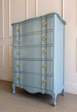Load image into Gallery viewer, A classic French Provincial silhouette refreshed with a clean, modern lacquer finish. This vintage five-drawer chest features softly shaped drawer fronts, a gently serpentine apron, and cabriole-style feet that give it an elegant, airy profile. Finished in a custom Parma Gray mix, the color reads as a sophisticated blue-gray that shifts beautifully with natural light, and it’s completed with polished brass ginkgo leaf hardware for a warm, sculptural contrast. Good Bones Furniture