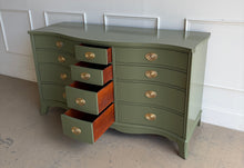 Load image into Gallery viewer, This vintage mahogany dresser makes a strong statement with its elegant serpentine front and generous twelve-drawer layout. The shaped case gives the piece movement and softness, while the symmetrical drawer configuration keeps the overall look balanced and refined. Professionally lacquered in Farrow & Ball Bancha, the finish brings a rich olive green depth that feels classic, tailored, and quietly dramatic. Good Bones Furniture