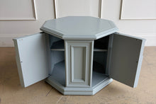 Load image into Gallery viewer, Professionally lacquered in Benjamin Moore Boothbay Gray, this vintage octagonal accent cabinet blends Hollywood Regency glamour with architectural neo-classical detailing. The octagonal silhouette, recessed panel molding, and arched faux-door styling give the piece strong boutique showroom presence. End table. Good Bones Furniture