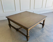 Load image into Gallery viewer, The Wellmington Coffee Table is a beautiful statement piece that brings both character and functionality to any living space. Crafted from solid Mango wood, it features stunning large bobbin legs and cross braces that highlight its traditional craftsmanship. The substantial square design ensures ample surface area, making it perfect for both decorative displays and everyday use. Good Bones Furniture