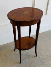 Load image into Gallery viewer, This elegant Wildwood accent table draws heavily from classic Federal and Regency design, featuring an oval silhouette, tapered saber legs, and richly patterned mahogany veneers inspired by fine English antiques. The proportions feel graceful and architectural, while the warm finish and decorative inlay work give the piece exceptional depth and character. Good Bones Furniture