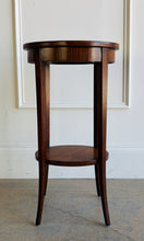 Load image into Gallery viewer, This elegant Wildwood accent table draws heavily from classic Federal and Regency design, featuring an oval silhouette, tapered saber legs, and richly patterned mahogany veneers inspired by fine English antiques. The proportions feel graceful and architectural, while the warm finish and decorative inlay work give the piece exceptional depth and character. Good Bones Furniture