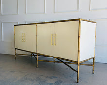 Load image into Gallery viewer, Rear angled view of the Ambella Home faux bamboo cabinet showcasing bamboo-style legs, metal frame detailing, and refined Palm Beach resort silhouette.